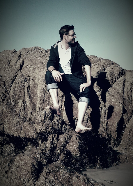 Sentado em rochas no Oceano Pacífico